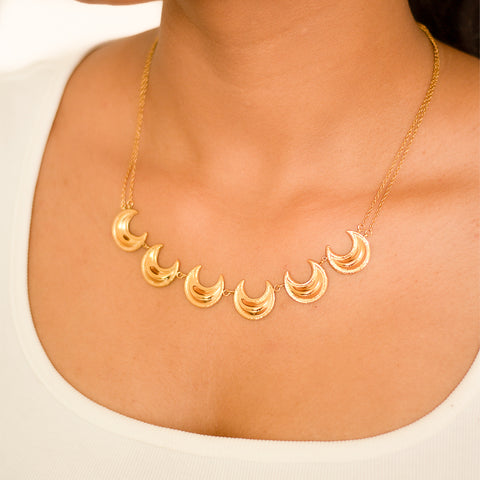 Add a touch of celestial elegance with the Moonlit Grace Necklace! This stunning necklace features a beautifully designed moon pendant, perfect for those who love to stargaze. Shine bright and capture the moon's grace in this unique piece.  Material: Stainless Steel Plating: 18K Gold-Plated Waterproof Hypoallergenic Anti-tarnish
